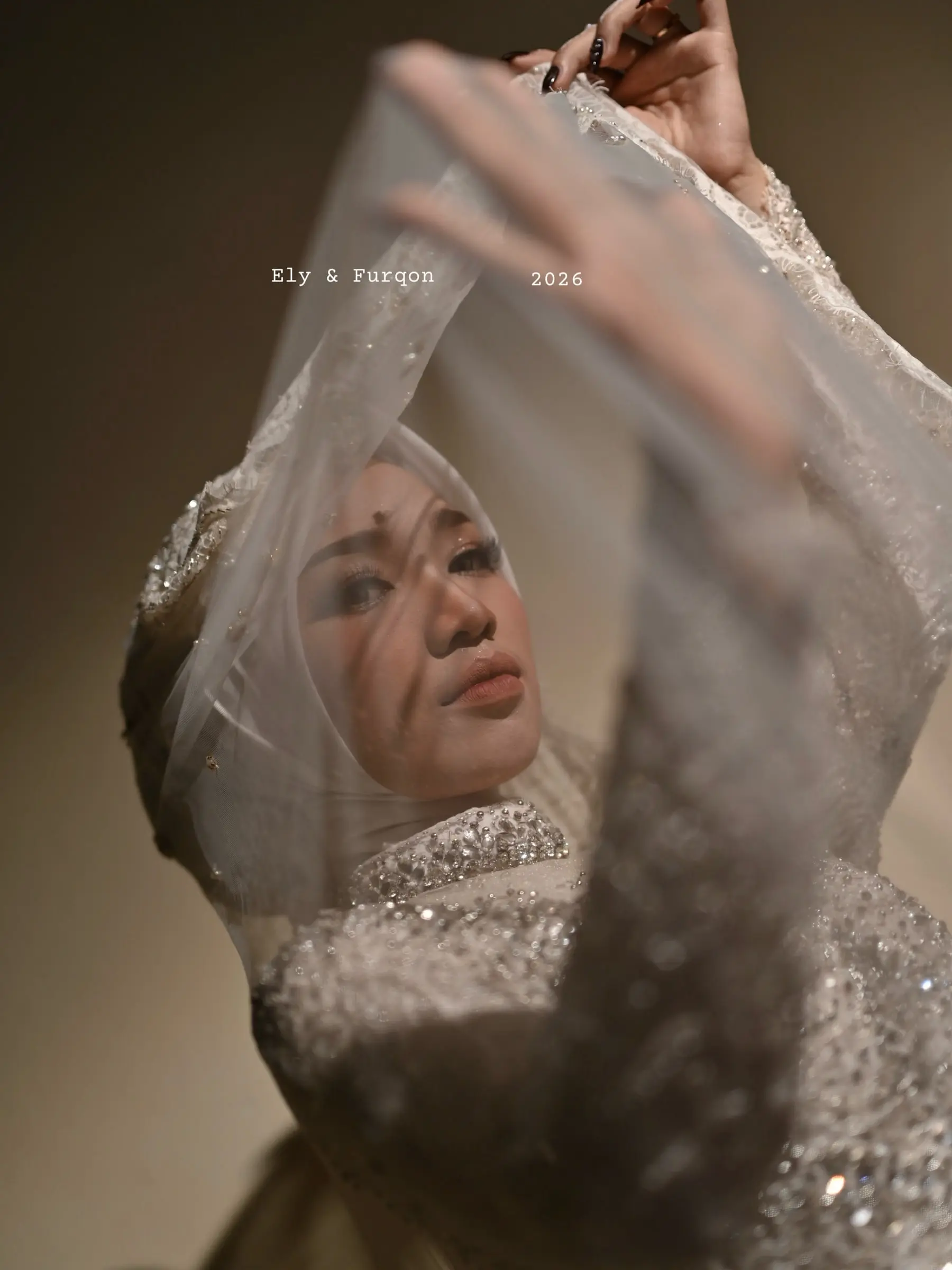 Pengantin wanita mengangkat kerudung renda berpayet