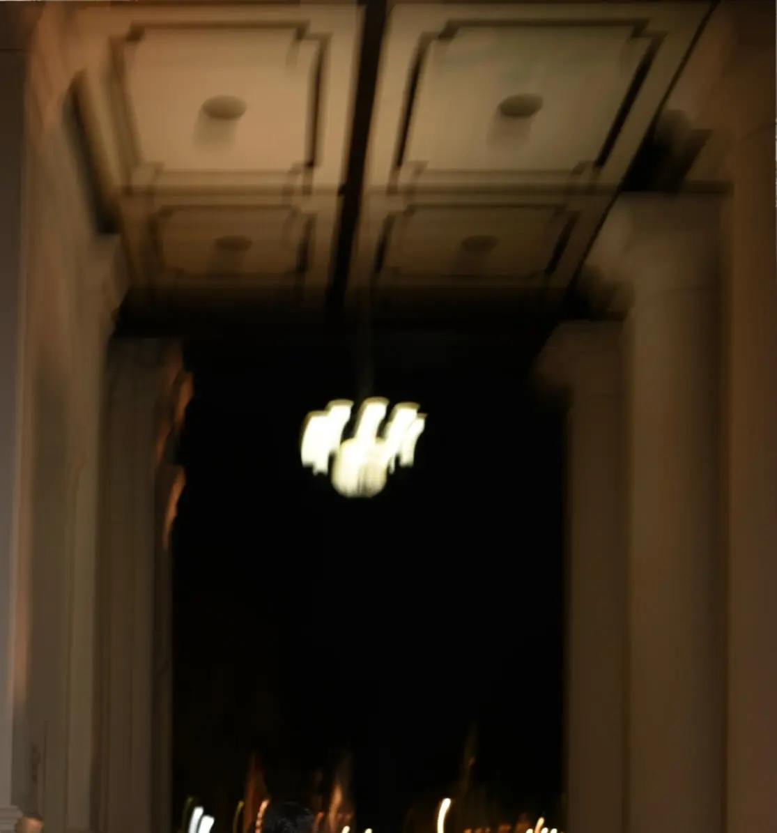Pasangan prewedding berbusana putih di lorong bangunan tua dengan lampu gantung pada malam hari